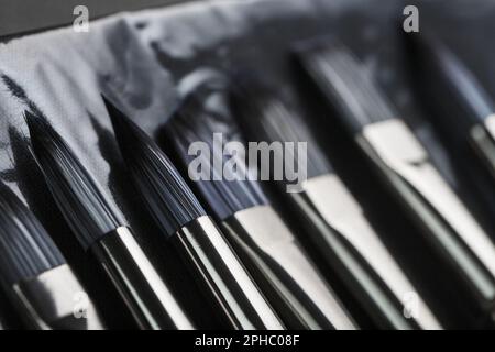Paint tubes, brushes for painting and palette knifes on old wooden background Stock Photo