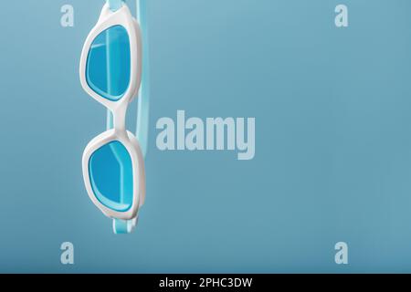 Swimming goggles in a white frame with a blue filter on a blue background Stock Photo