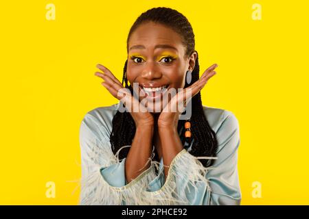 African Lady With Bright Makeup Holding Hands Near Face, Studio Stock Photo