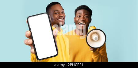 Mobile Offer. Two Black Male Demonstrating Big Blank Smartphone And Using Loudspeaker Stock Photo