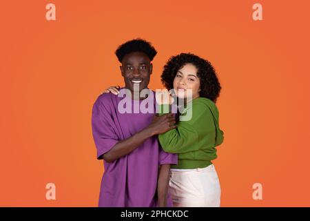 Loving beautiful mixed race couple, embracing, smiling at camera Stock Photo