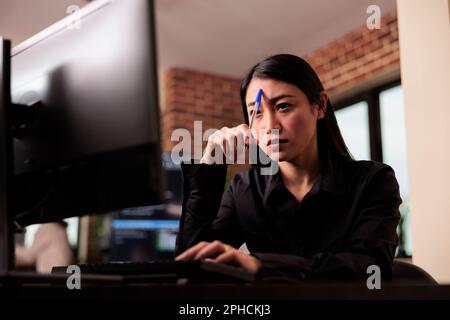 Tired tech enginner brainstorming ideas about coding solution, finding algorithm to create database script. Feeling pensive and thinking about software developing system in it agency Stock Photo