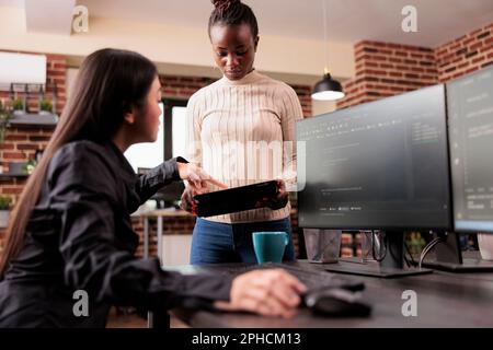 Team of software developers debugging algorithm working in it developing agency. Programming engineers analyzing source code on computer monitor, comparing data script in busy agency office. Stock Photo
