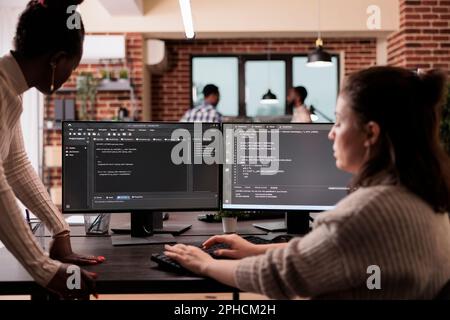 Programming engineers using computer to write code and develop algorithm program. Software developers working on user interface with html script and terminal window in development company. Stock Photo