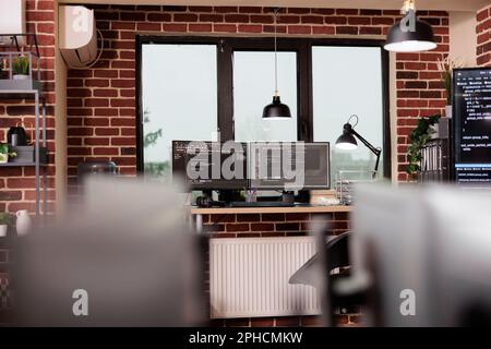 Desk table with multiple monitors running terminal window and artificial intelligence programming database script. Empty it programming agency office with servers cloud computing. Coding concept Stock Photo