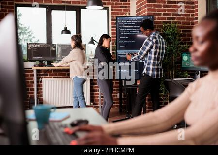 Tech enginners using binary code to script security system, programming firewall encryption. Diverse team working with program data server to develop network on coding software. Programmer concept Stock Photo
