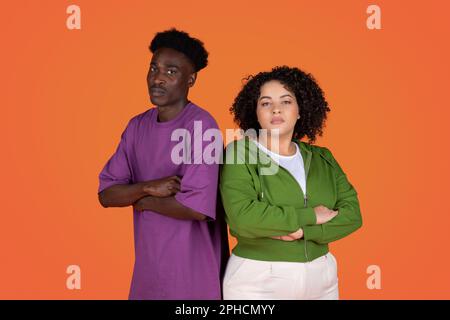 Upset couple standing back to back on red background Stock Photo
