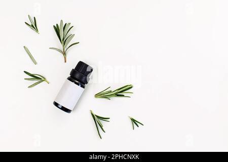 Rosemary essential oil isolated on white background, top view. Bottle with empty label Stock Photo