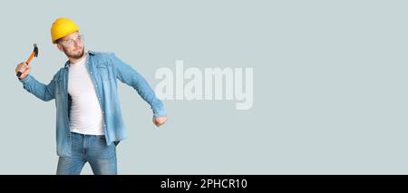 Male worker with hammer on light background with space for text Stock Photo