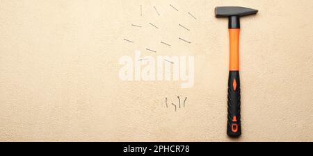 Builder's hammer with nails on light background with space for text Stock Photo