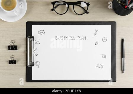 Flat lay composition of clipboard with words Business Plan on wooden table Stock Photo