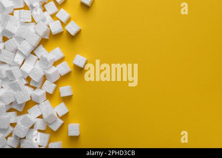 Many styrofoam cubes on yellow background, flat lay. Space for text Stock Photo