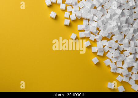 Many styrofoam cubes on yellow background, flat lay. Space for text Stock Photo