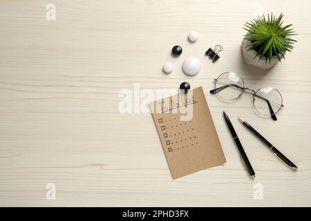 Flat lay composition with unfilled To Do list and houseplant on wooden table Stock Photo