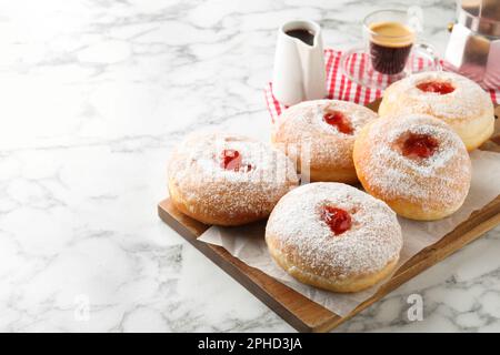 Delicious jam donuts served with coffee on white marble table. Space for text Stock Photo