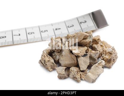 Pile of kidney stones and measuring tape on white background Stock Photo