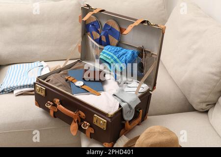 https://l450v.alamy.com/450v/2phd401/open-suitcase-with-different-men-clothes-and-accessories-on-sofa-2phd401.jpg