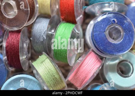 Bobbins in a variety of vibrantly colored thread, ready to start sewing. Stock Photo