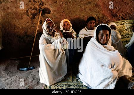 Ethiopian pilgrims sitting inside the Church of Saint George in Lalibela, Ethiopia during Easter week. Stock Photo