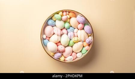 A bowl of easter eggs on a beige background Stock Photo