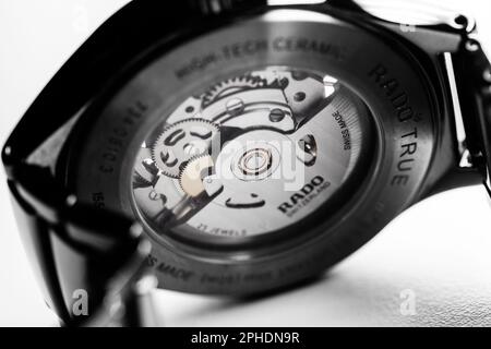 Lengnau, Switzerland - November 11, 2021: Transparent glass back side of self-winding mechanic Swiss watch. Rado Automatic Open Heart 734.0510.3 Stock Photo