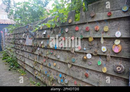 Zierikzee, The Netherlands August 27th 2020 - Plein Montmaertre - Wooden discs with wishes hang on a wooden fence Stock Photo