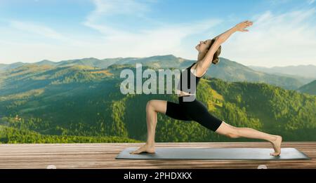 Young woman practicing yoga on wooden surface against beautiful mountain landscape, space for text. Banner design Stock Photo