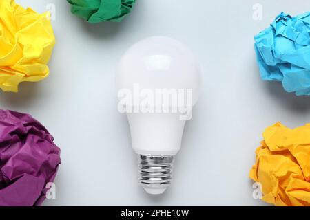 Creative flat lay composition with lightbulb and paper balls on white background. Idea concept Stock Photo