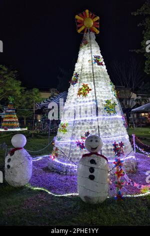 Colorfully lit fir tree with Christmas decorations in Siquijor in the Philippines made from recycled material. Stock Photo