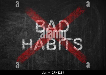 Phrase Bad Habits crossed with red lines on blackboard Stock Photo
