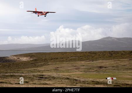 A Falkland Islands Government Air Service (FIGAS) Islander aircraft coming in to land at Saunders island, part of the Falkland Islands. Stock Photo