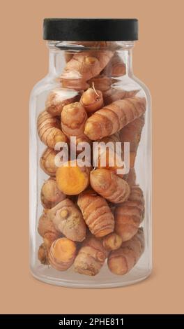 cleaned turmeric rhizomes or roots in glass bottle, curcuma longa, commonly used spice in cooking and medicine, root-like structure isolated Stock Photo