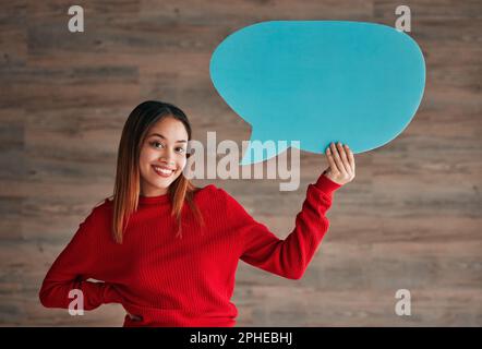 Business woman, speech bubble and smile by wall in portrait with opinion, social media mockup and workplace. Businesswoman, paper and poster for news Stock Photo