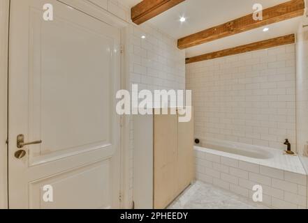 Interior design of modern bathroom with white bathtub shower cabin with wooden cabinets placed under ceiling with wooden logs decorative support Stock Photo