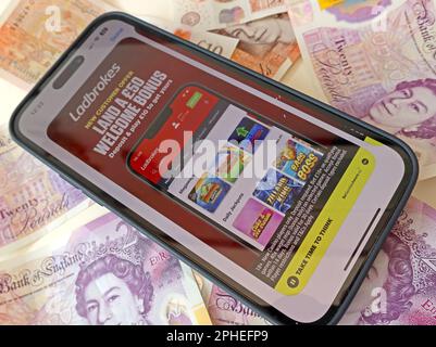 Ladbrokes Smartphone App - Online and smartphone casino, slots and gambling app with English Sterling notes, money easily lost - BeGambleAware Stock Photo