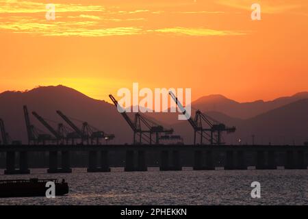 Silhouette of cranes on the pier in the evening. Stock Photo