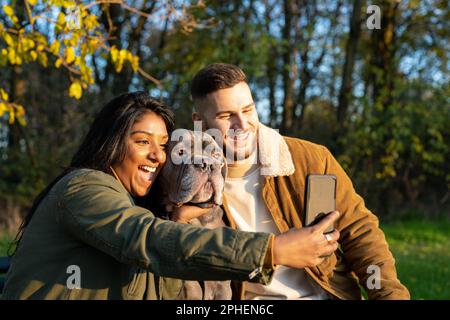 Young couple taking selfie with pet, people loves gods concepts Stock Photo