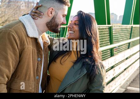 Young lovers cuddling, young Indian woman with her boyfriend having tender and romantic moment outside Stock Photo