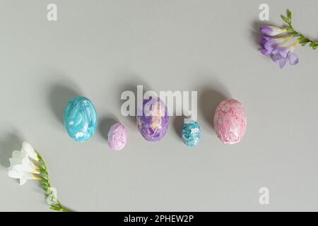 Happy Easter. Easter multicolored eggs on a light gray background. Greeting card, horizontal banner with copy space, top view. Creative Easter composi Stock Photo
