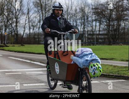 Essen, Germany. 28th Mar, 2023. A cyclist simulates a full braking with a cargo bicycle in which an unsecured child is sitting. At the presentation of a campaign for responsible use of cargo bicycles, Landesverkehrswacht demonstrated the dangers using crash tests. Credit: Oliver Berg/dpa/Alamy Live News Stock Photo