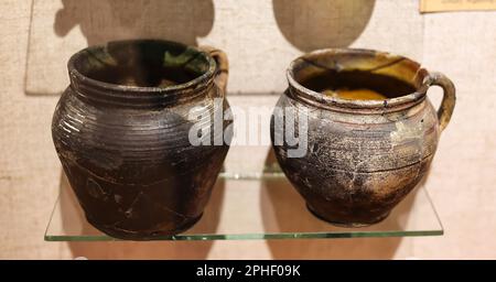 Old vintage, ancient Ukrainian ceramic clay jugs on a glass stand Stock Photo