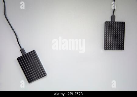 Portable black Hard Drive HDD isolated on grey background. Cool flat lay top view, copy space. Data storage concept for computers laptops,technology Stock Photo