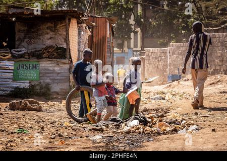 Children playing in the middle of the street in Kibera slum, Nairobi, Kenya. Kibera is the biggest slum in Africa and one of the biggest in the world. It houses an estimated population of 1 million people living in a situation of extreme poverty. A vast majority of the people lack access to basic services and medical care: only about 20% of Kibera has electricity, and the water that reaches its shacks is not clean and causes typhoid and cholera. In most of Kibera there are no toilet facilities. Unemployment rates are high and most people cannot afford education for their children. Stock Photo