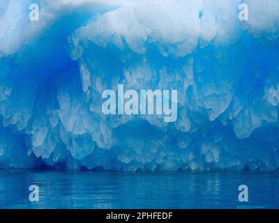 Iceberg in the fjord with melt structure. Landscape in the Johan Petersen Fjord, a branch of the Sermilik (Sermiligaaq) Icefjord in the Ammassalik reg Stock Photo