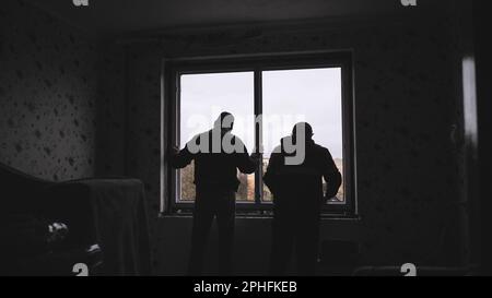 Silhouettes of workers installing new plastic windows. Stock Photo