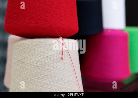 Colorful cotton yarn cones for textile industry close up. Selective focus. Stock Photo