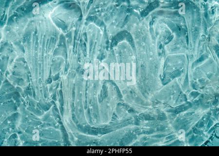 Dynamic clear gel swatch splash with air bubbles in blue water light. Hydrating face cream. Beauty cosmetic product background Stock Photo