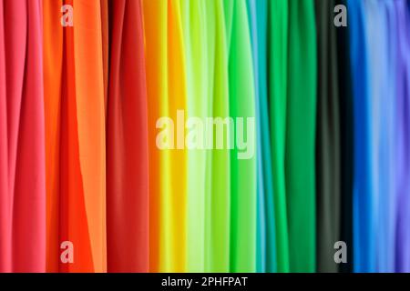 Multicolored fabrics samples in textile store. Abstract rainbow colored background. Selective focus. Stock Photo