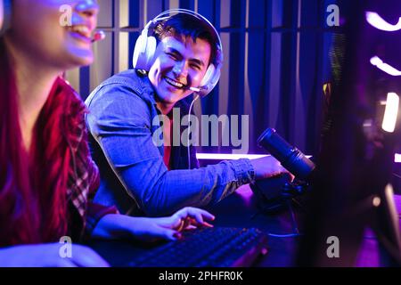 Young female and male gamers playing video game while spending weekend ...