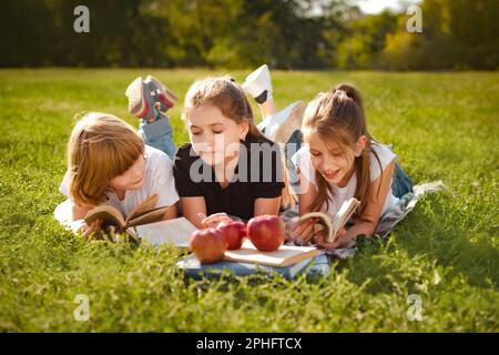 Kids reading literature. Boy and girls learning or studying. Teenage children having school education. Pupils holding textbooks getting knowledge Stock Photo